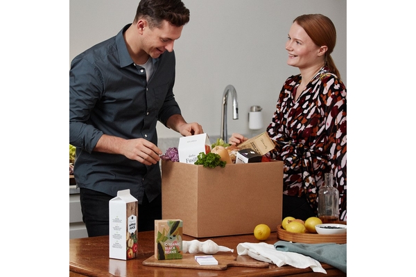 Image Man and woman unpacking box of food.